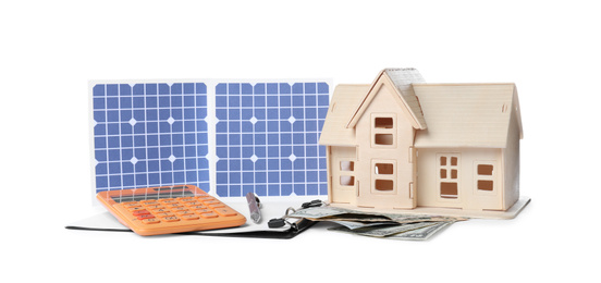 Photo of Composition with solar panels and wooden house model on white background