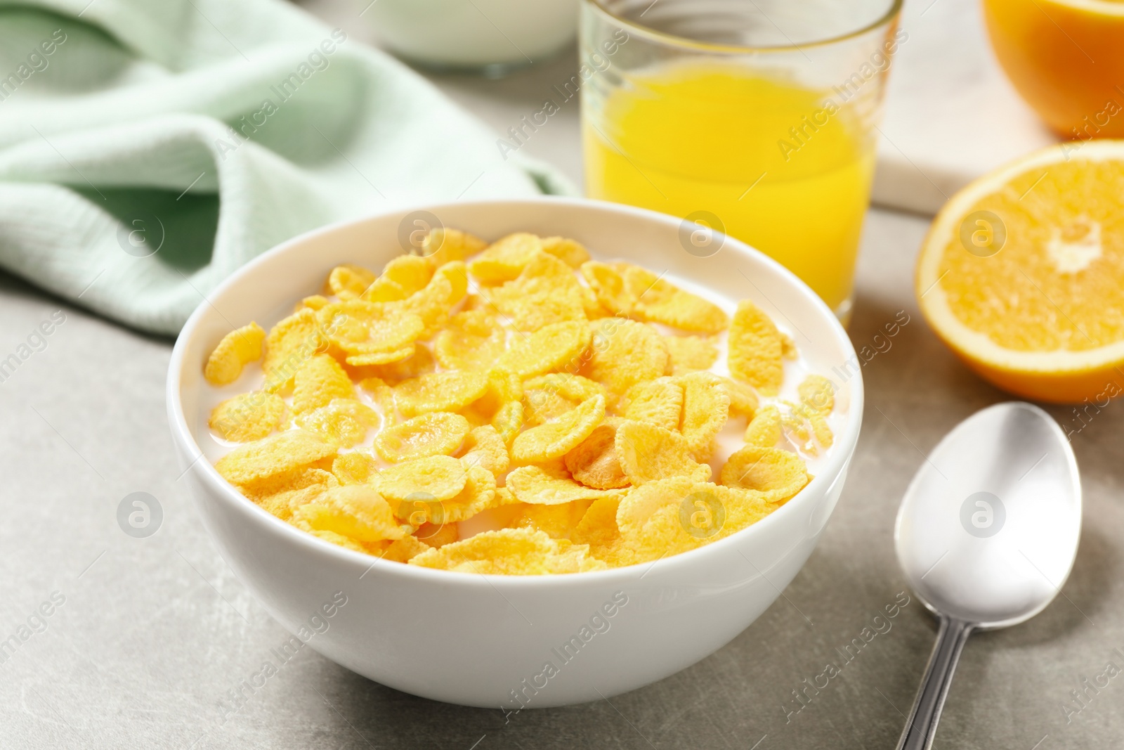 Photo of Tasty corn flakes with milk on light grey table