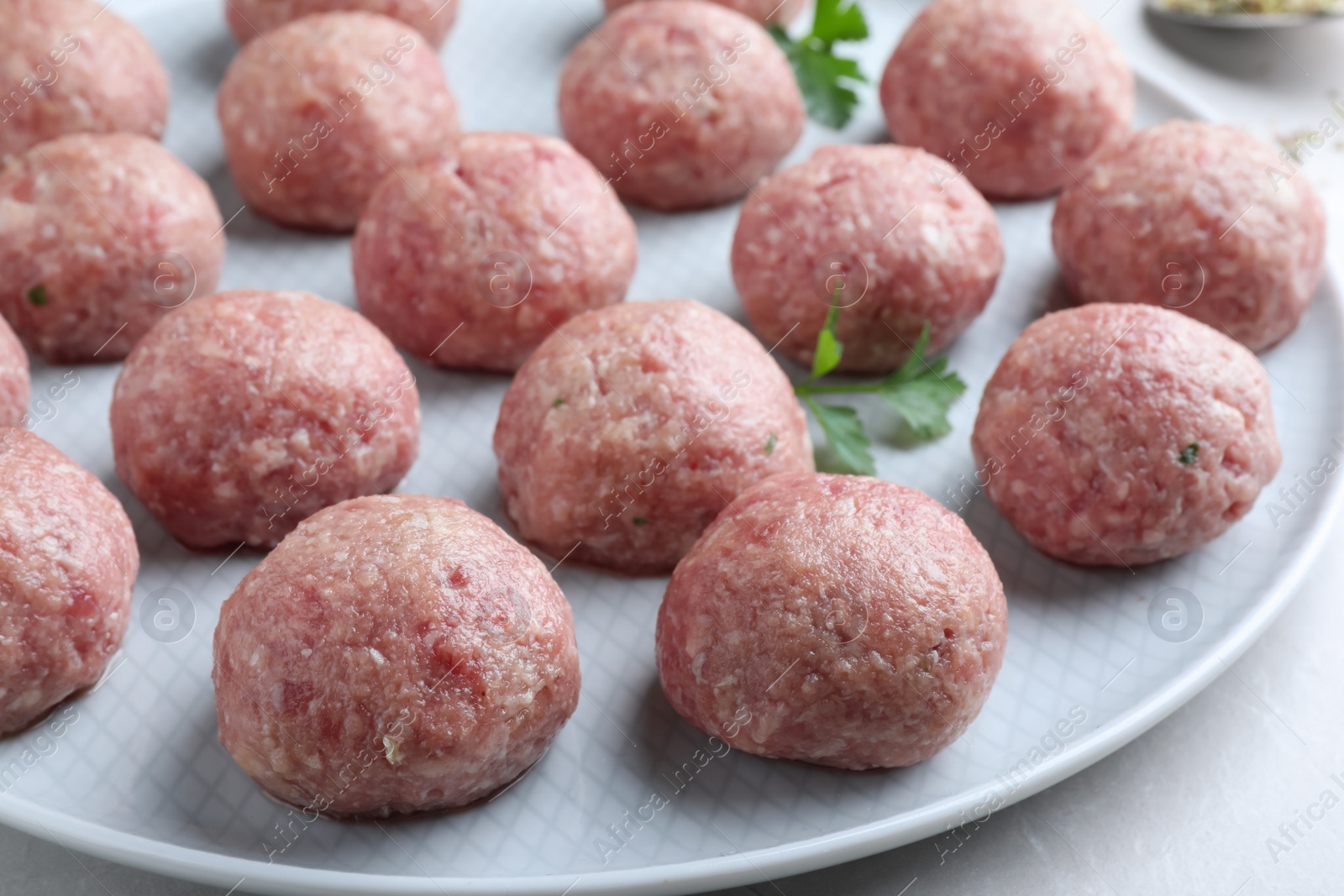 Photo of Many fresh raw meatballs on light table, closeup