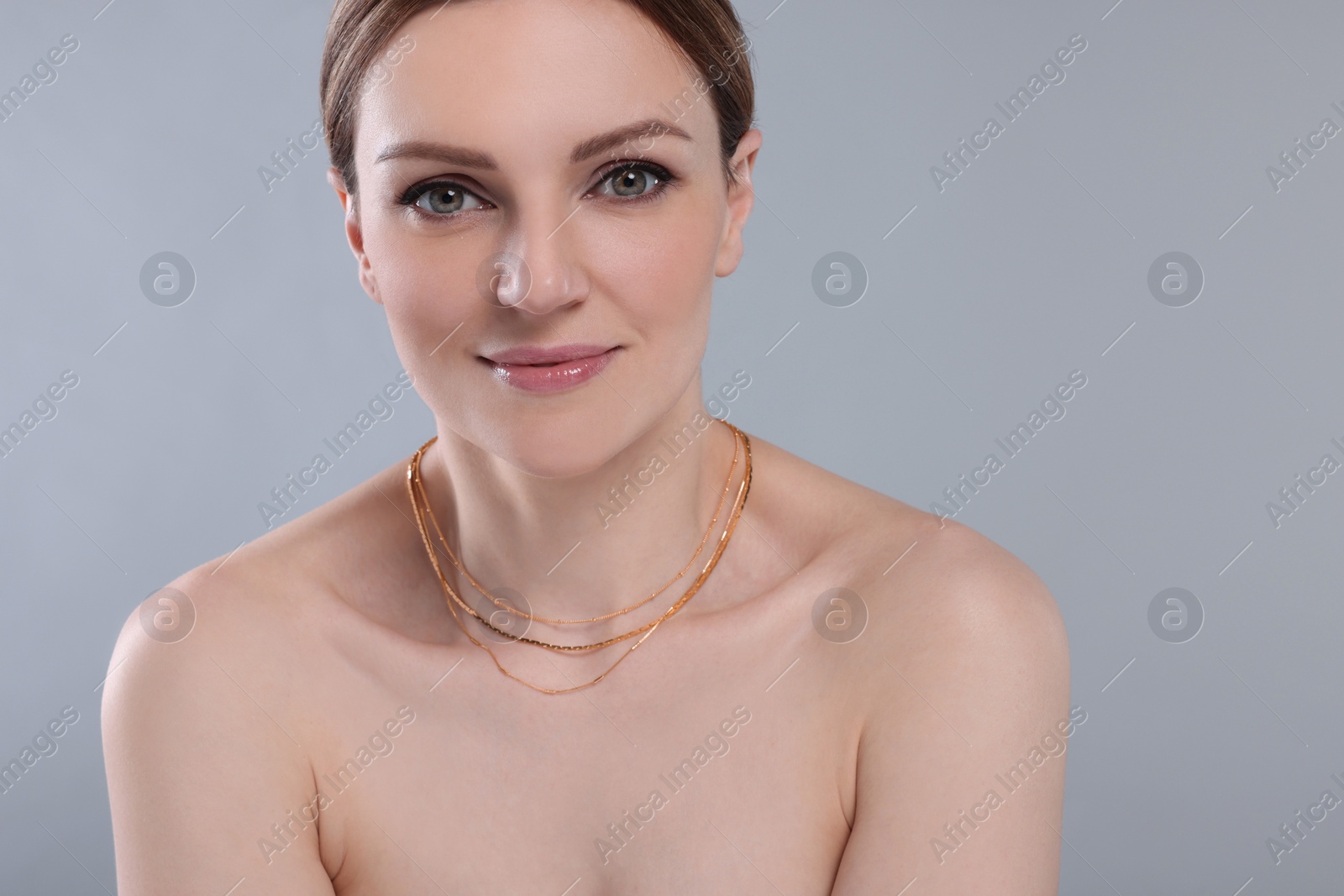 Photo of Beautiful woman with elegant necklace on light grey background