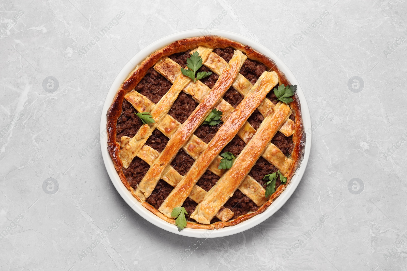 Photo of Freshly baked meat pie on light grey table, top view