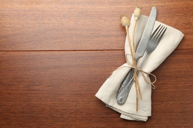 Photo of Stylish setting with cutlery and napkin on wooden table, top view. Space for text