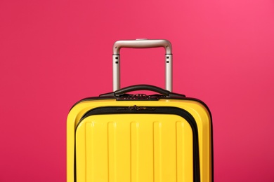 Stylish carry on suitcase on color background