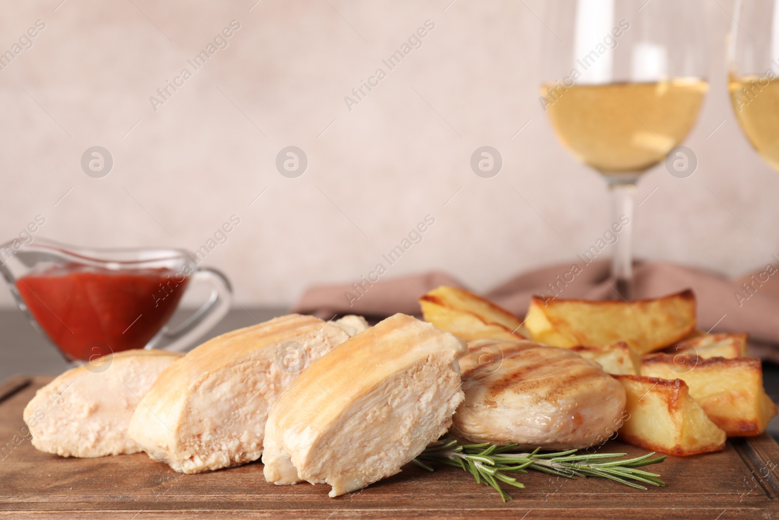 Photo of Grilled meat served with garnish, sauce and wine on table. Space for text