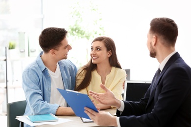 Photo of Young couple meeting with consultant in office