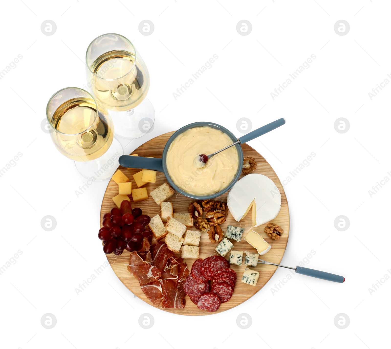 Photo of Fondue with tasty melted cheese, forks, different snacks and wine isolated on white, top view