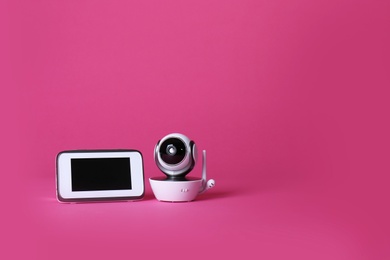 Photo of Modern CCTV security camera and monitor on color background. Space for text