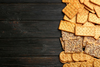 Photo of Many delicious crackers on wooden table, flat lay. Space for text