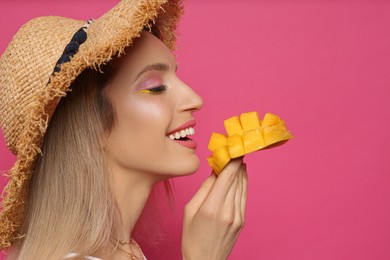 Photo of Young woman with fresh mango on pink background. Exotic fruit
