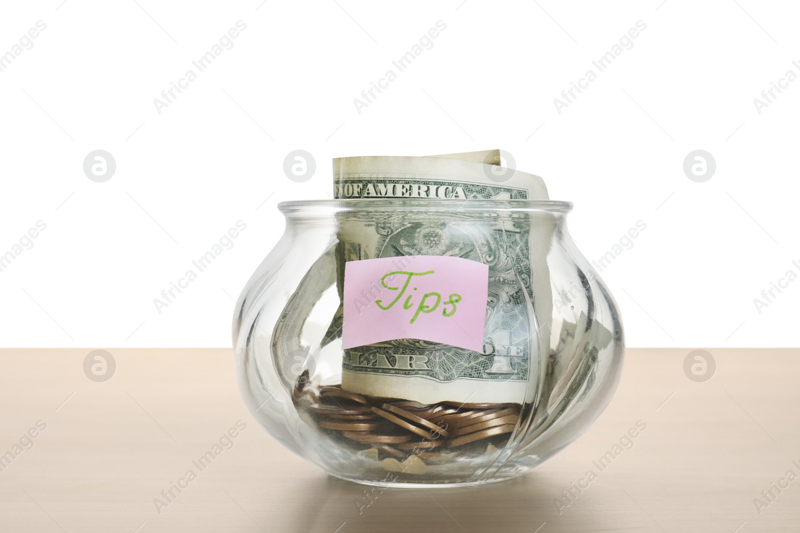 Photo of Tip jar with money on wooden table against white background