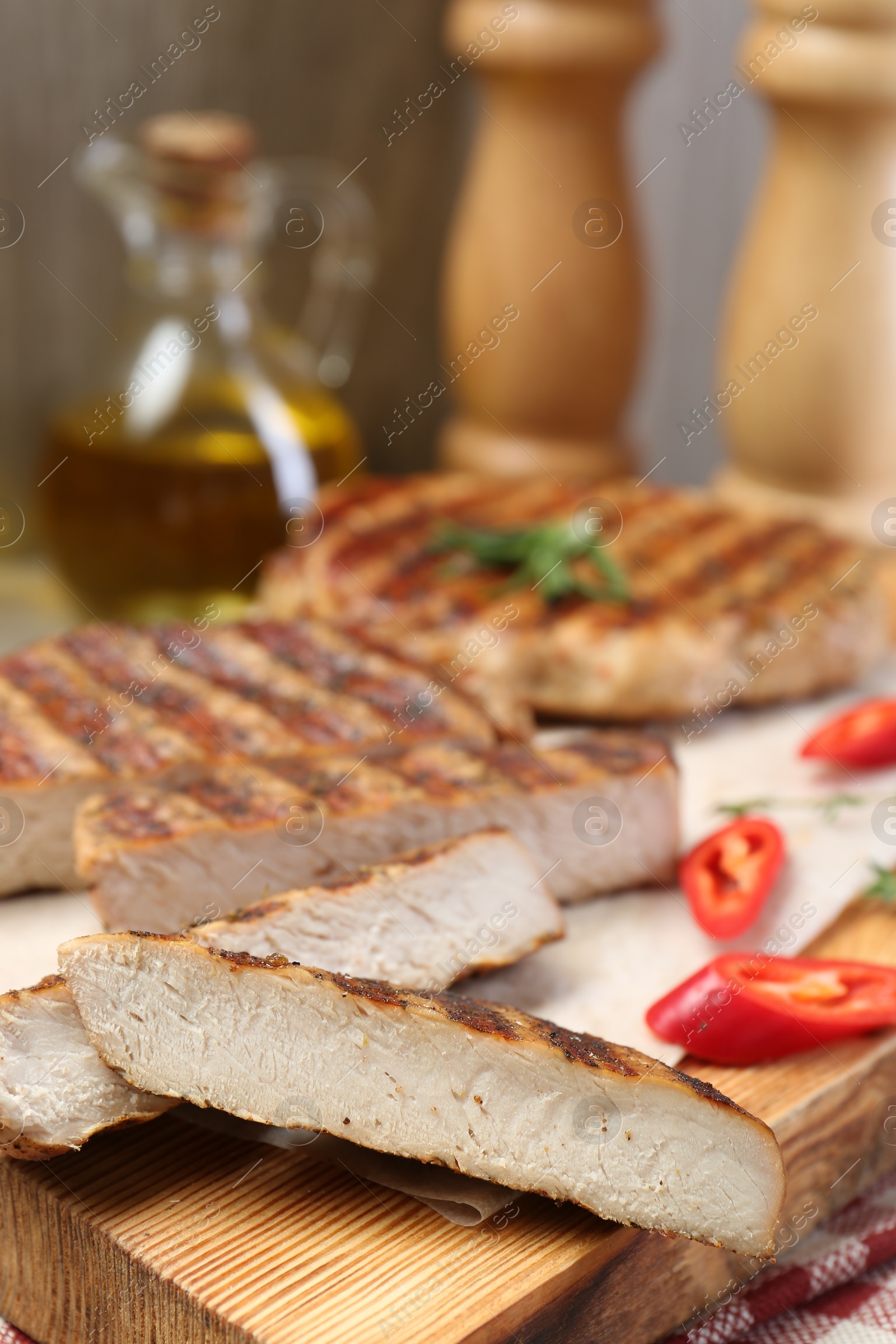 Photo of Cut grilled pork steaks on table, closeup