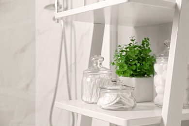 Cotton swabs and other hygiene products on shelving unit in bathroom