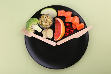 Photo of Metabolism. Plate with different food products and wooden cutlery on light background, top view