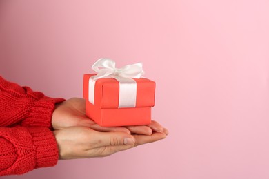 Photo of Woman holding gift box on pink background, space for text. Valentine's Day celebration