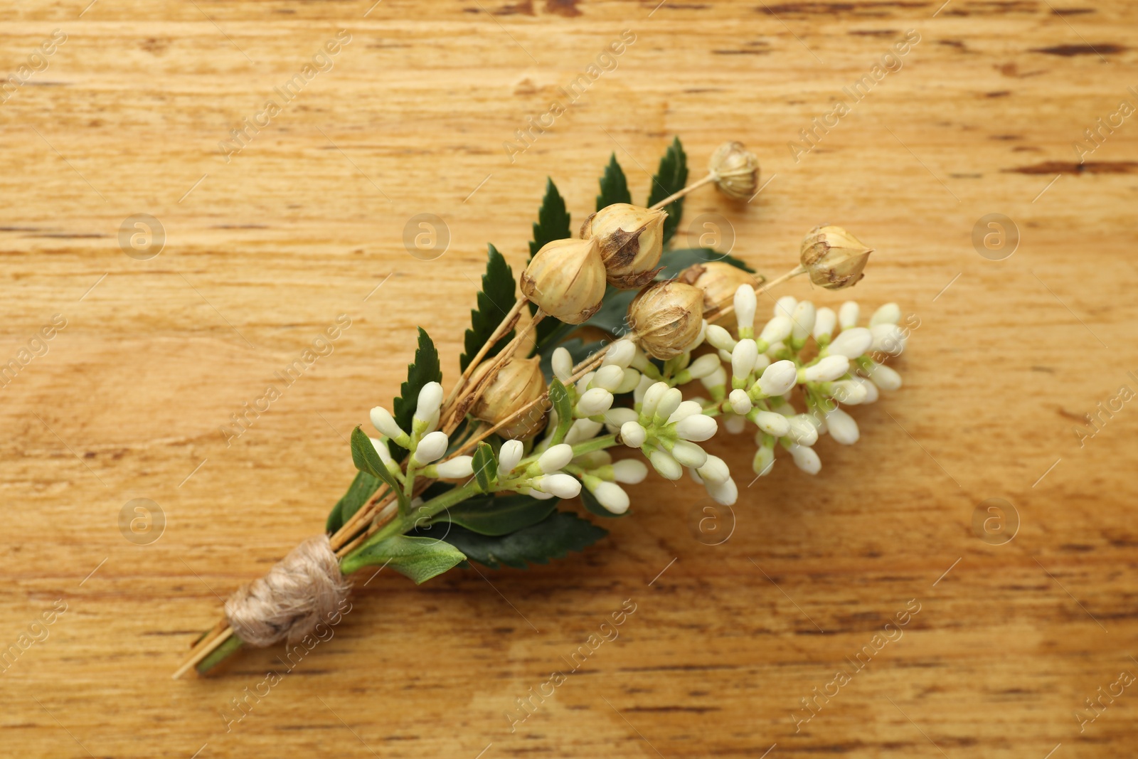 Photo of Small stylish boutonniere on wooden table, top view