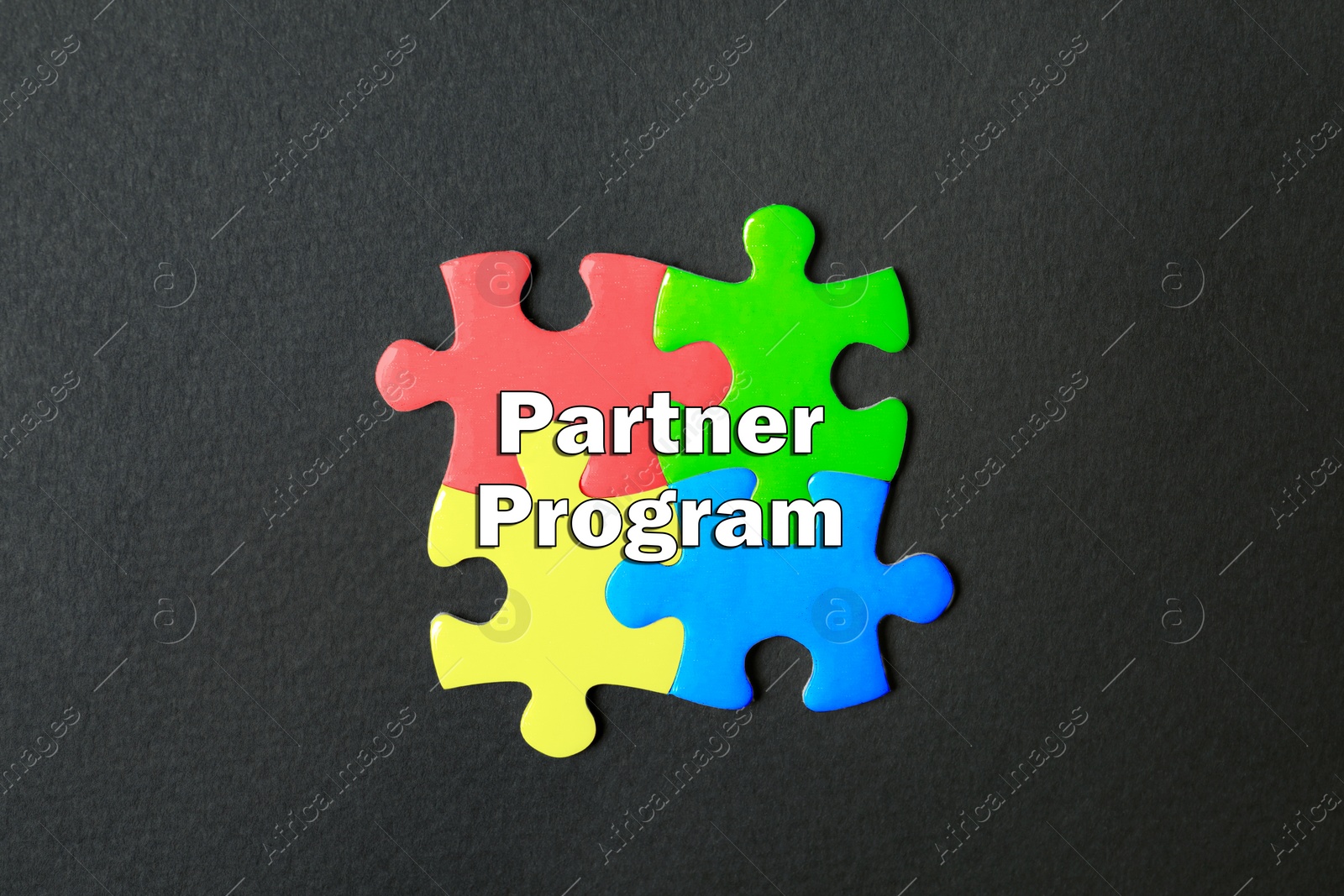 Image of Jigsaw puzzle pieces with words Partner Program on black background, top view