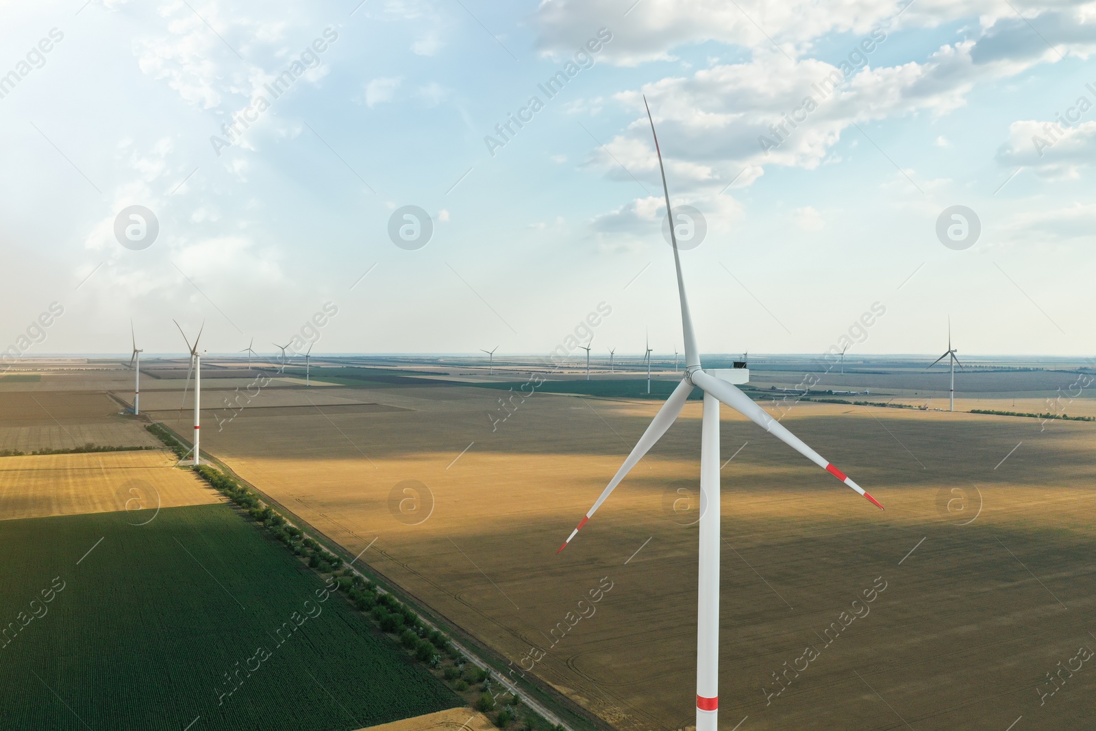 Photo of Modern windmill in field, space for text. Energy efficiency