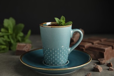 Photo of Cup of delicious hot chocolate with fresh mint on grey table