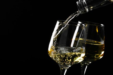 Photo of Pouring tasty aromatic wine in glass on black background, closeup. Space for text