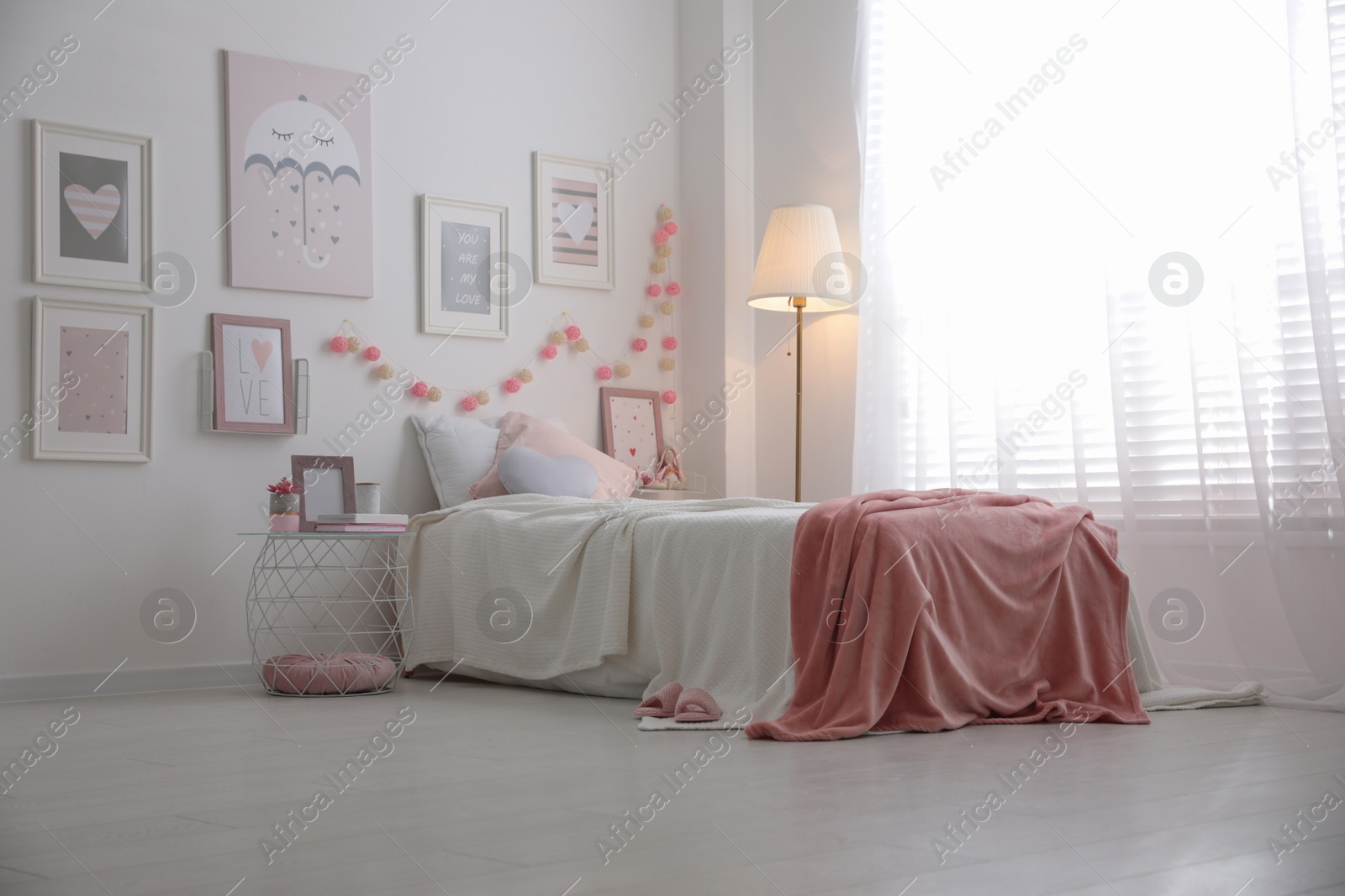 Photo of Modern teenager's room interior with comfortable bed and beautiful pictures