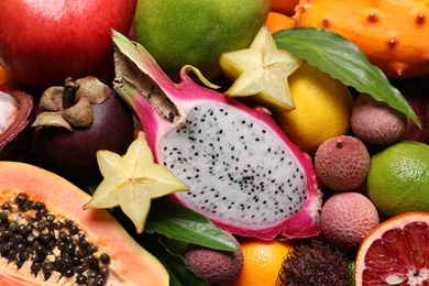 Different delicious exotic fruits as background, top view