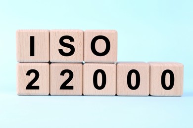 International Organization for Standardization. Wooden cubes with abbreviation ISO and number 22000 on light blue background