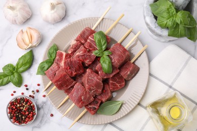 Flat lay composition with cut fresh beef meat on white marble table