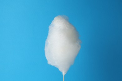 Photo of One sweet cotton candy on light blue background