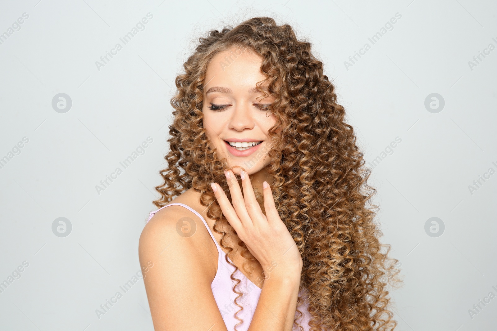 Photo of Portrait of beautiful young woman with shiny wavy hair on color background