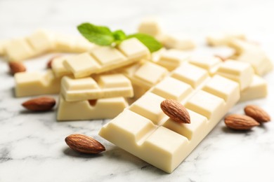 Delicious white chocolate with almonds on marble table, closeup