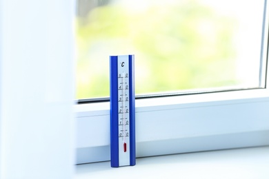 Weather thermometer on window sill indoors. Space for text