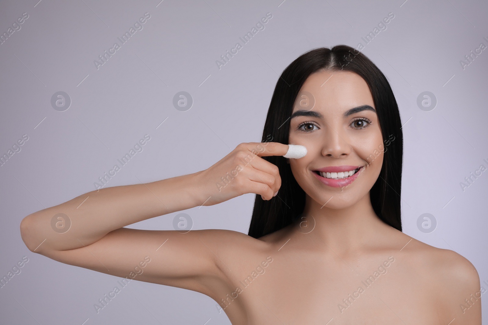 Photo of Woman using silkworm cocoon in skin care routine on light grey background. Space for text