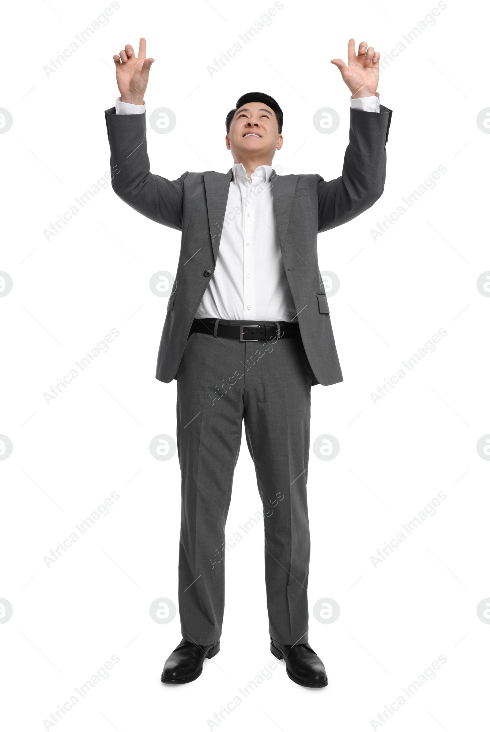 Photo of Businessman in suit posing on white background, low angle view