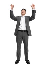 Businessman in suit posing on white background, low angle view