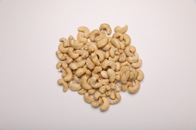 Pile of tasty cashew nuts on white background, top view