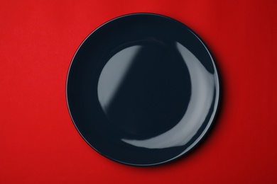 Clean empty plate on color background, top view