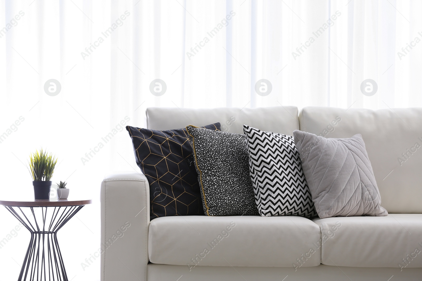 Photo of Comfortable sofa with different soft pillows indoors