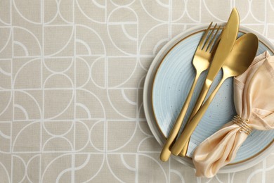 Stylish setting with cutlery, plates and napkin on table, top view. Space for text