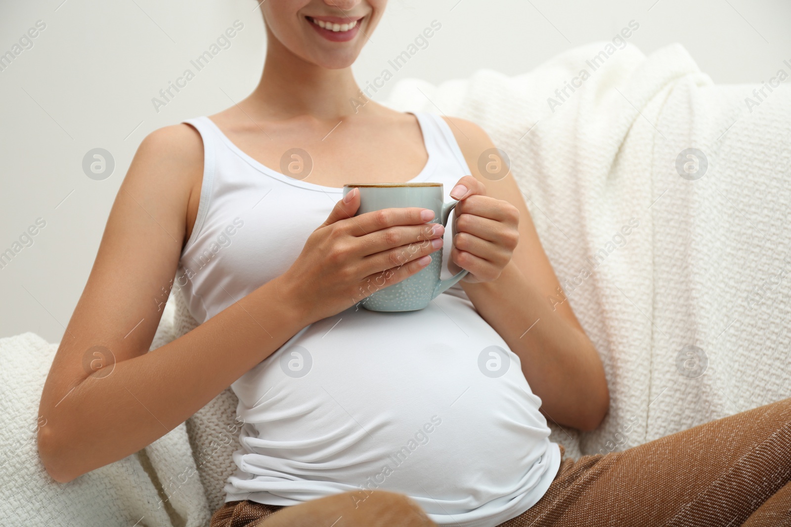 Photo of Pregnant woman drinking tea at home, closeup