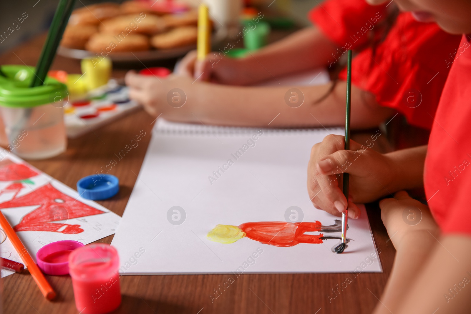 Photo of Little child painting picture at home. Christmas celebration