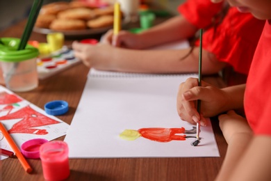 Little child painting picture at home. Christmas celebration