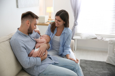 Happy couple with their newborn baby at home