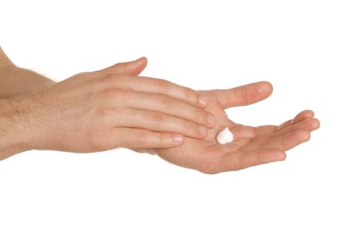 Man applying cream onto hand against white background, closeup