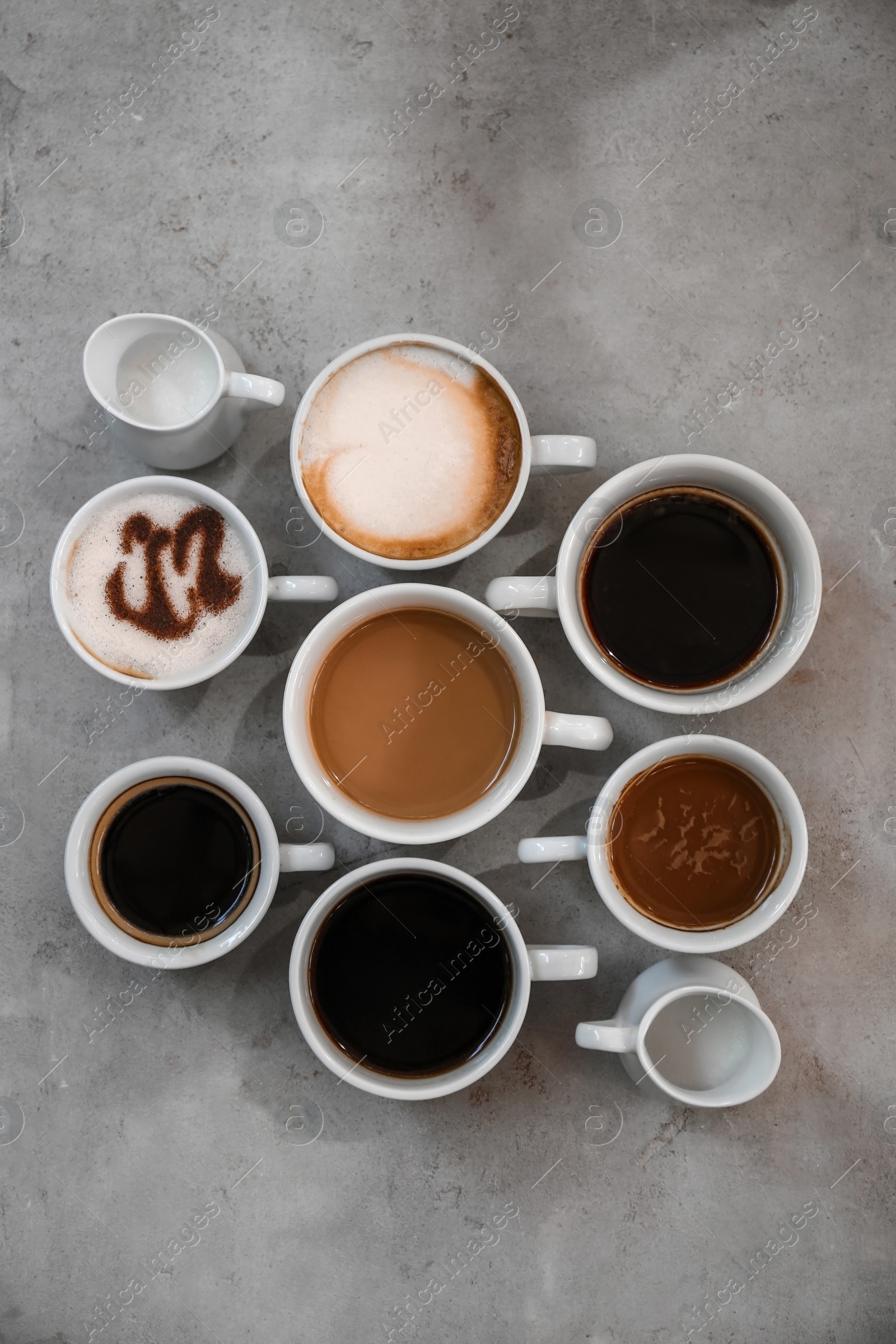 Photo of Cups of fresh aromatic coffee on grey background, top view