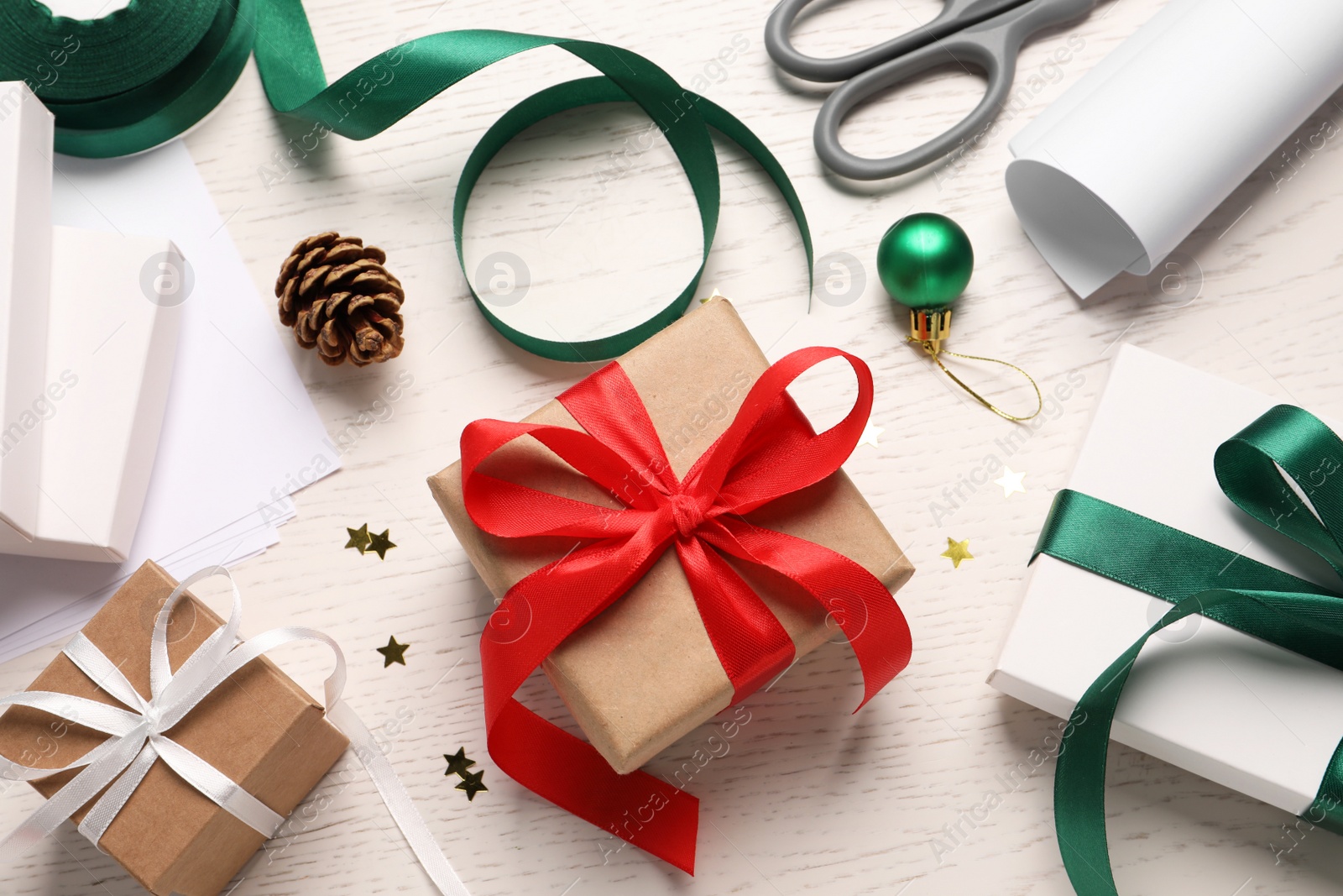 Photo of Flat lay composition with beautiful gift boxes and Christmas decorations on white wooden table