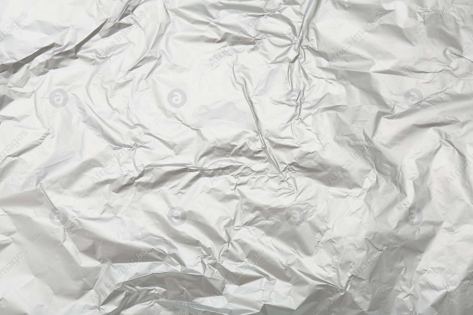 Photo of Crumpled silver foil as background, top view