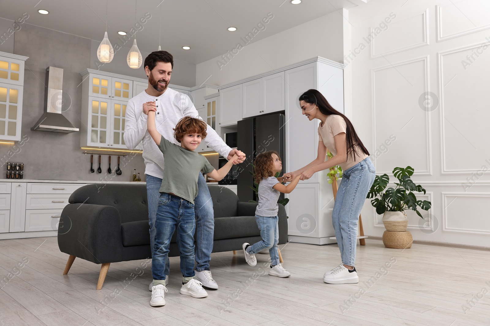 Photo of Happy family dancing and having fun at home, low angle view