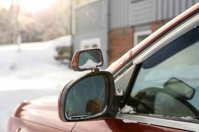 Side view mirror of car on snowy winter day, closeup