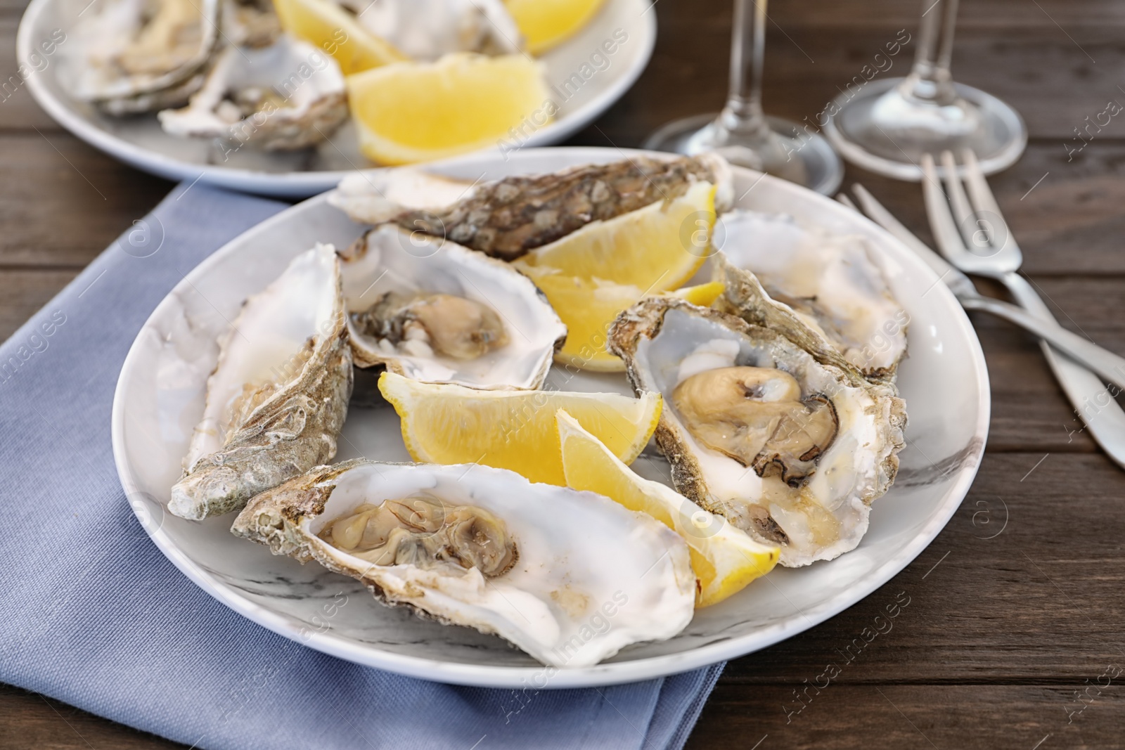 Photo of Fresh oysters with cut juicy lemon served on table