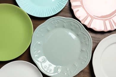 Beautiful ceramic plates on wooden table, flat lay